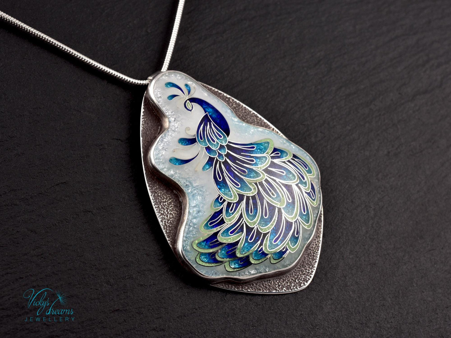 Handmade sterling silver peacock pendant with colorful enamel and artistic design.