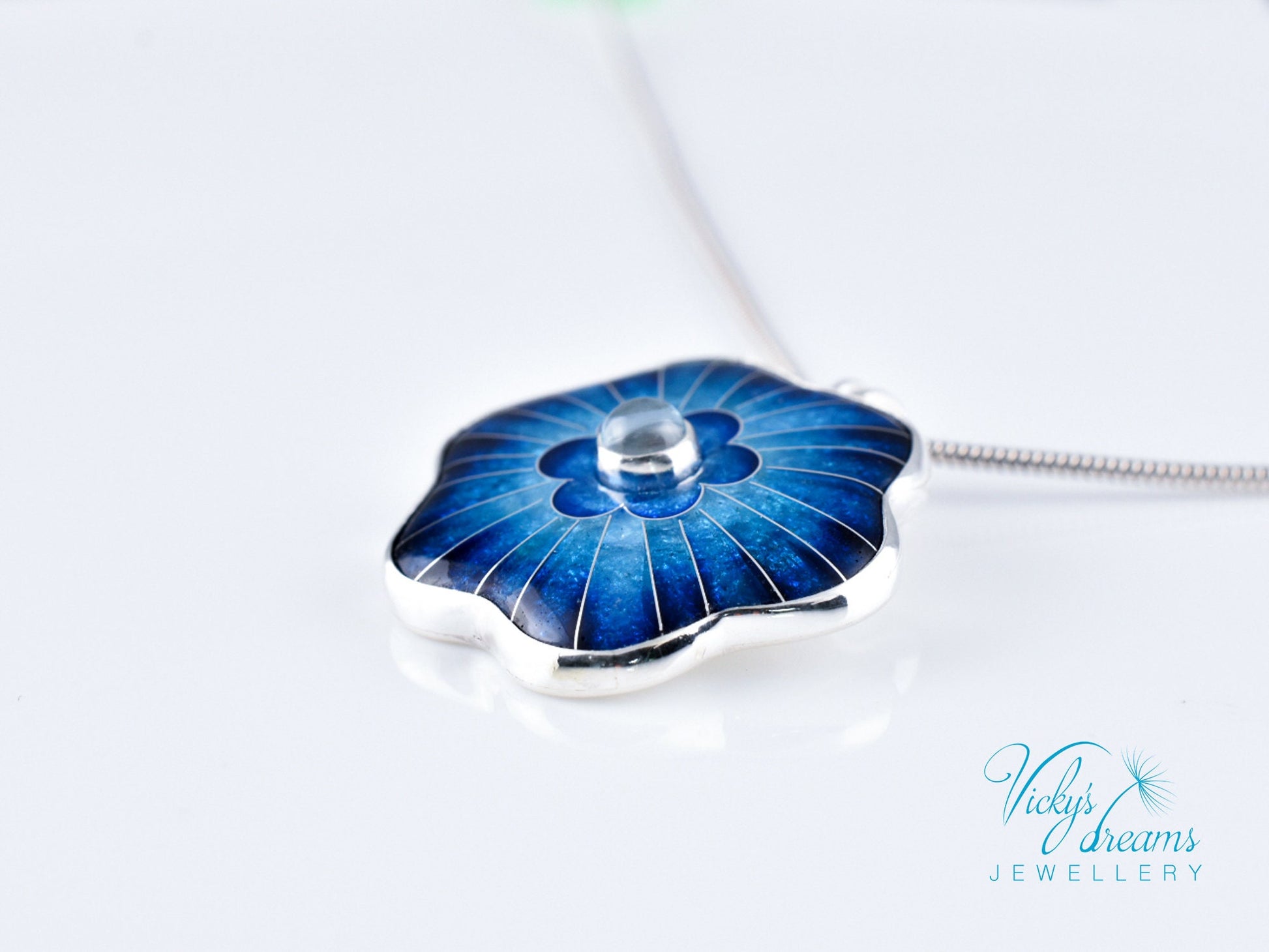 Cloisonné blue flower pendant with natural sky blue topaz set in sterling silver.