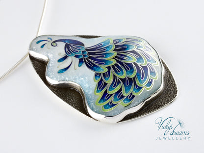 Handmade sterling silver peacock pendant with colorful enamel and artistic design.